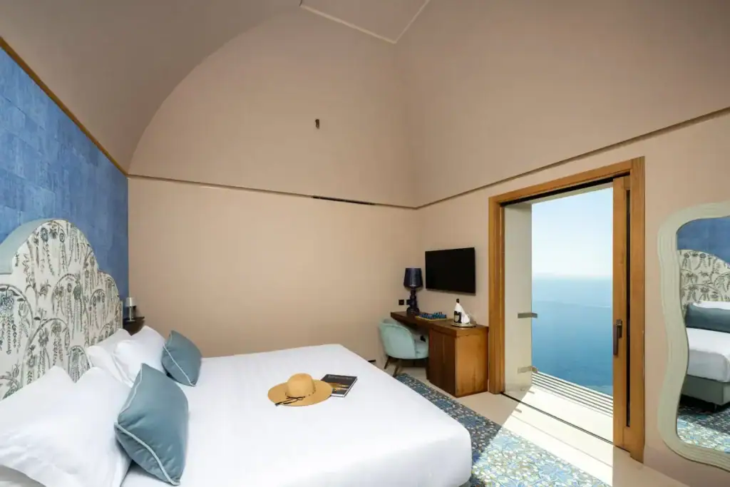 Elegant hotel room with sea view, modern decor, and stylish furnishings.
