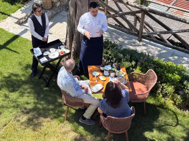 A tasting at a table in the garden, with the chef and staff